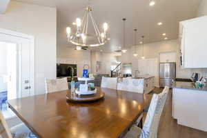 Dining area with suspended lighting, dark wood-style flooring, a high ceiling, and a ceiling fan