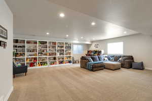 Living area with light carpet and recessed lighting