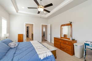 Bedroom featuring a walk in closet, light carpet, a ceiling fan, a raised ceiling, and recessed lighting