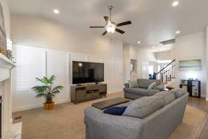 Living area with a decorative wall, a ceiling fan, a premium fireplace, and recessed lighting