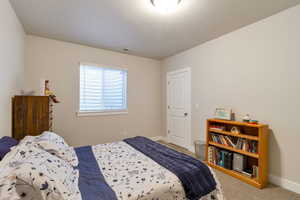 Bedroom featuring light colored carpet and baseboards