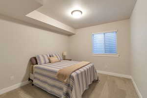 Bedroom with baseboards and light carpet