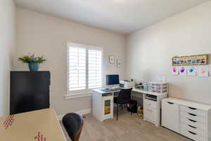 Home office featuring light colored carpet and baseboards