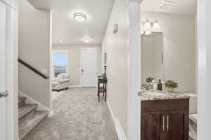 Hallway featuring light colored carpet and a textured ceiling