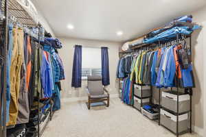 Walk in closet featuring light colored carpet