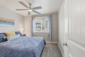Carpeted bedroom with baseboards and a ceiling fan