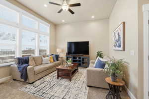 Living room featuring a ceiling fan, recessed lighting, and light colored carpet