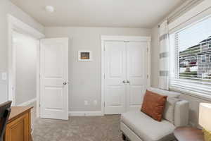 Living area featuring baseboards and light carpet