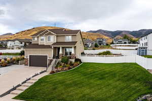View of front facade with a residential view, a mountain view, board and batten siding, concrete driveway, and a porch