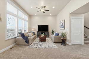 Living room featuring light carpet, ceiling fan, and recessed lighting