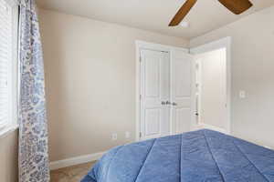 Bedroom featuring a ceiling fan, light colored carpet, and a closet