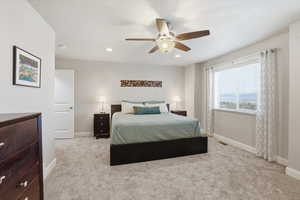 Bedroom featuring light colored carpet, a ceiling fan, and recessed lighting