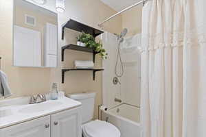 Full bath with shower / bath combo and storage cabinets on the right side of photo.