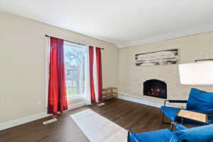 Living area with the original fireplace, large picture window and brick wall.
