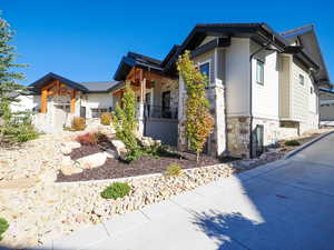View of property exterior featuring stone siding and a porch