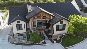 Back of property featuring a chimney and stairway