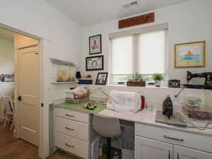 Office with dark wood-style floors and built in study area