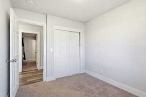 Unfurnished bedroom featuring light colored carpet and a closet