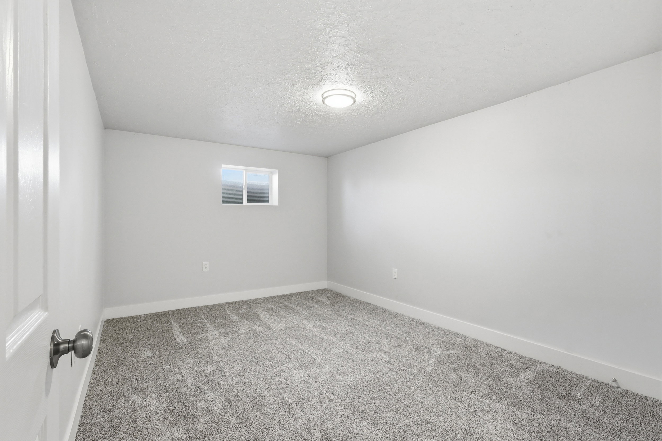 Unfurnished room with a textured ceiling and light carpet