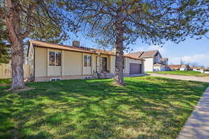 View of front of property with brick siding, concrete driveway, a garage, and a chimney