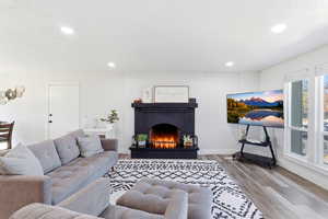 Living room featuring a fireplace, light wood-style flooring, and recessed lighting