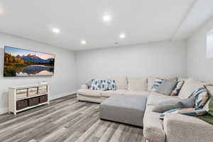 Living room with light wood finished floors and recessed lighting