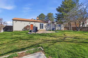 Rear view of house featuring a fenced backyard and a patio area