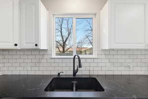 Kitchen featuring white cabinetry and dark stone counters