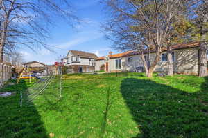 Back of house featuring a fenced backyard and a playground