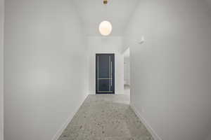 Hallway with baseboards and a high ceiling