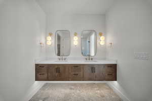 Bathroom featuring double vanity and baseboards