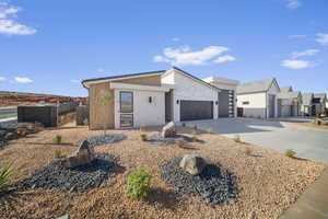 Contemporary house with an attached garage, driveway, and stone siding