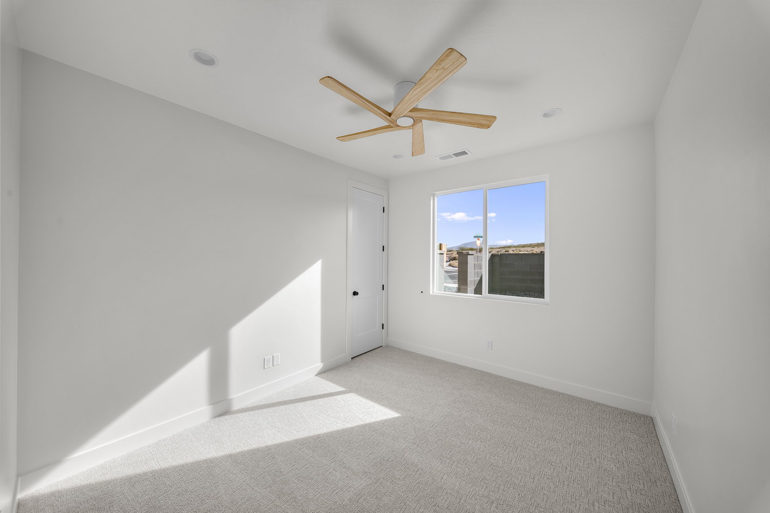 Unfurnished room featuring light carpet and ceiling fan