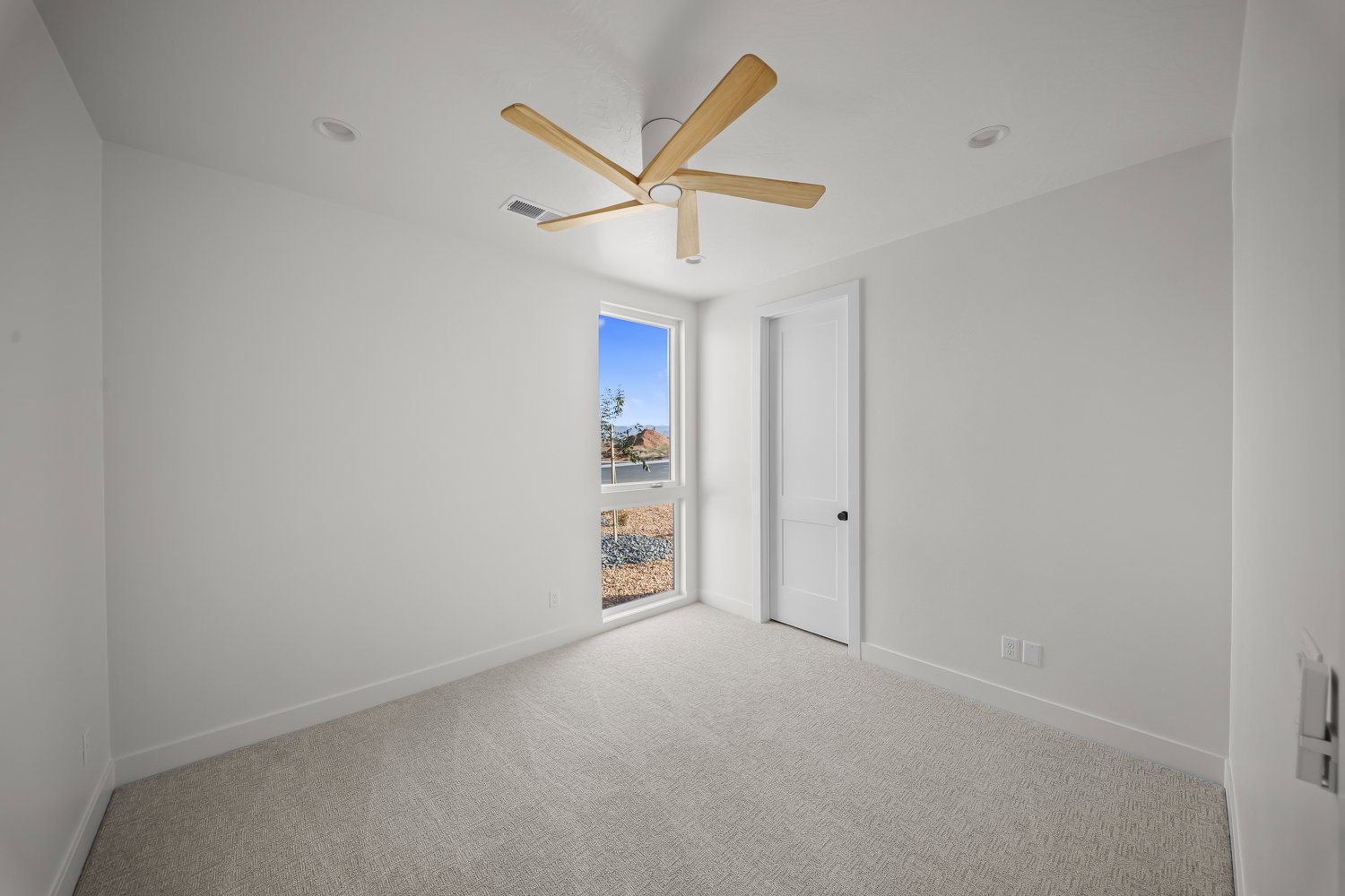 Spare room with light carpet and a ceiling fan