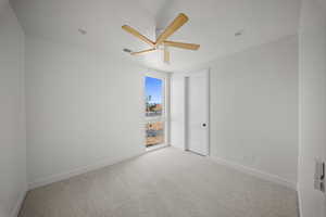 Spare room with light carpet and a ceiling fan