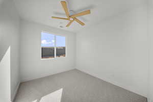 Empty room featuring carpet and a ceiling fan