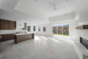 Kitchen featuring open floor plan, a center island with sink, modern cabinets, and healthy amount of natural light