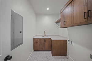 Laundry room featuring cabinet space, washer hookup, electric panel, and recessed lighting
