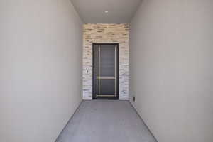 Entrance to property with a patio area and stone siding