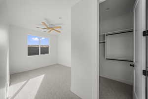 Unfurnished bedroom with light colored carpet and ceiling fan