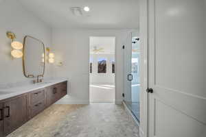 Full bathroom featuring double vanity, a shower stall, and ceiling fan