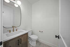 Half bathroom featuring vanity and baseboards