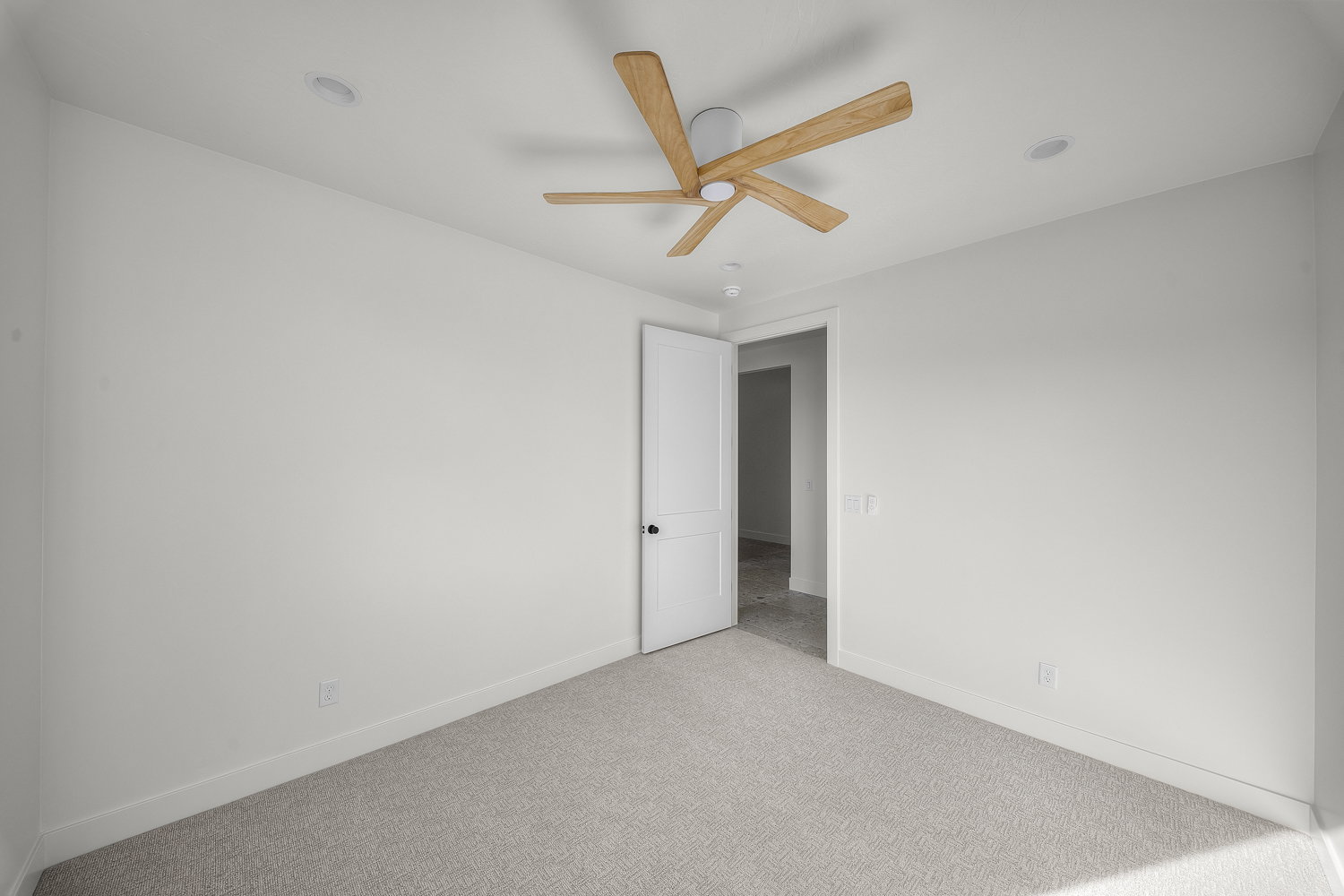 Spare room featuring light carpet and a ceiling fan