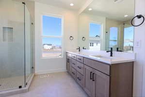 Primary Full bath featuring double vanity, a stall shower, healthy amount of natural light, light tile patterned floors, and recessed lighting