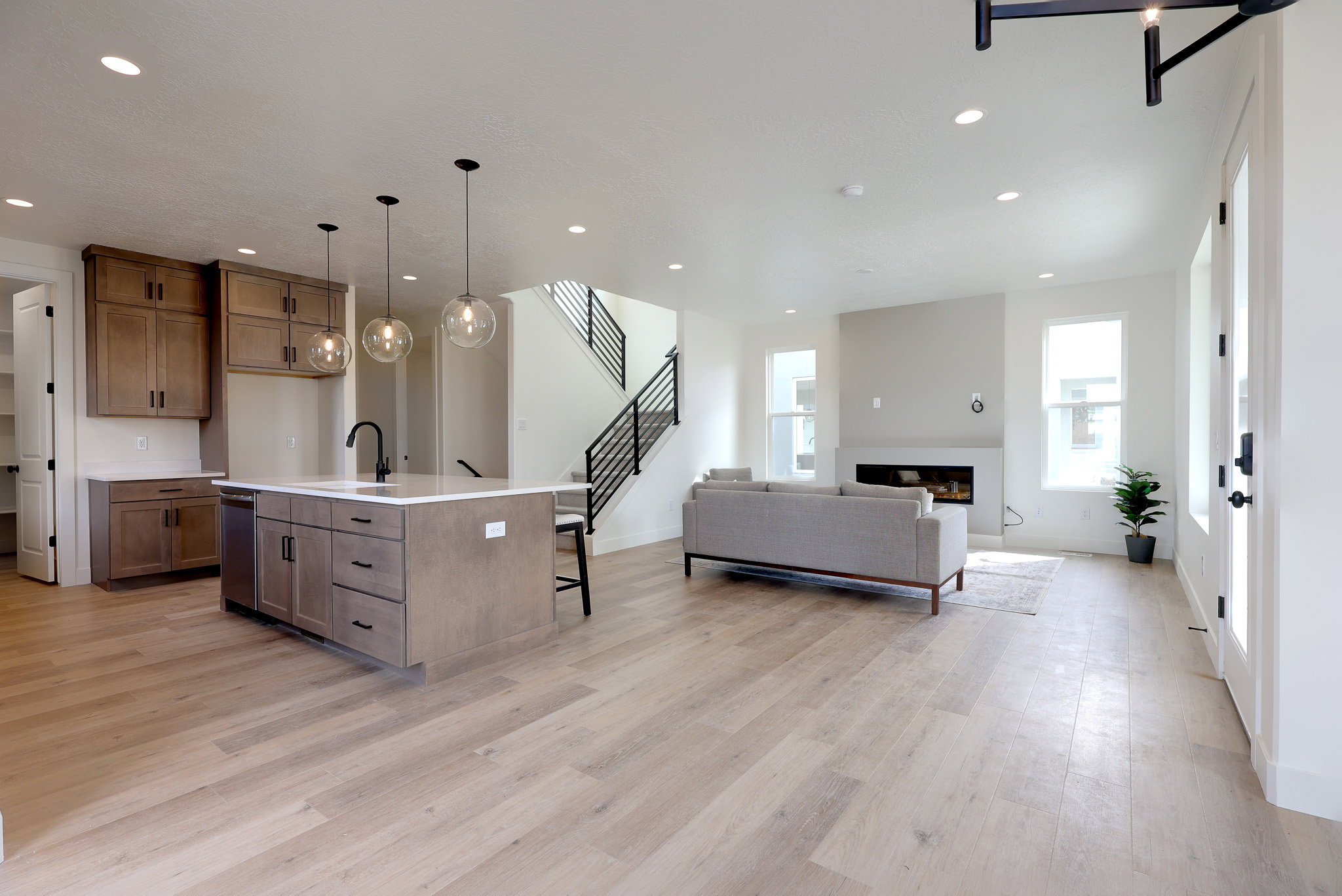 Kitchen featuring open floor plan, a breakfast bar, decorative light fixtures, an island with sink, and wood finish cabinetry