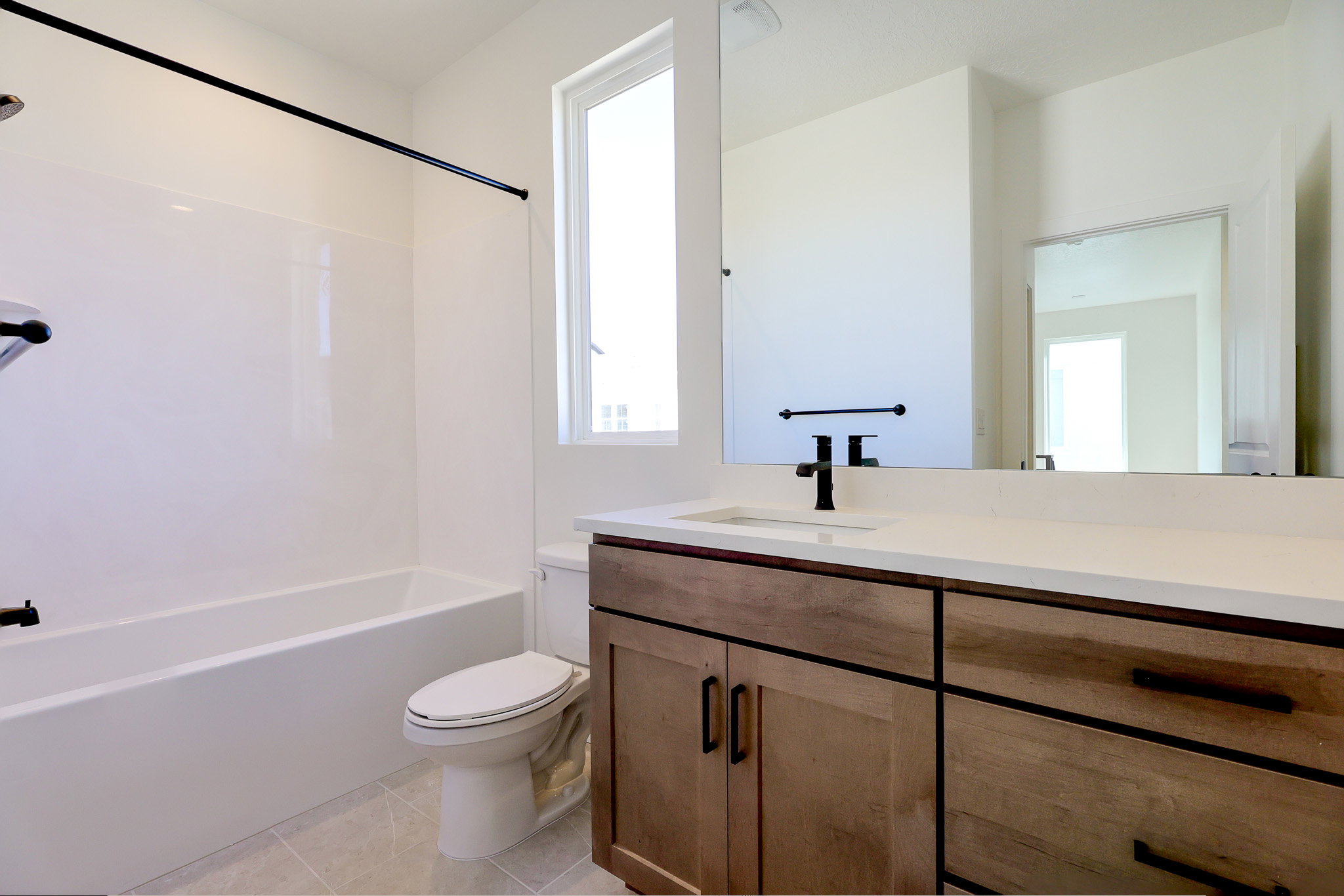 Full bath featuring vanity, plenty of natural light, shower / bath combination, and light tile patterned floors