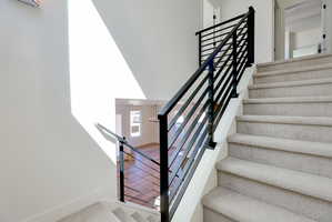Stairs featuring metal railing and a high ceiling