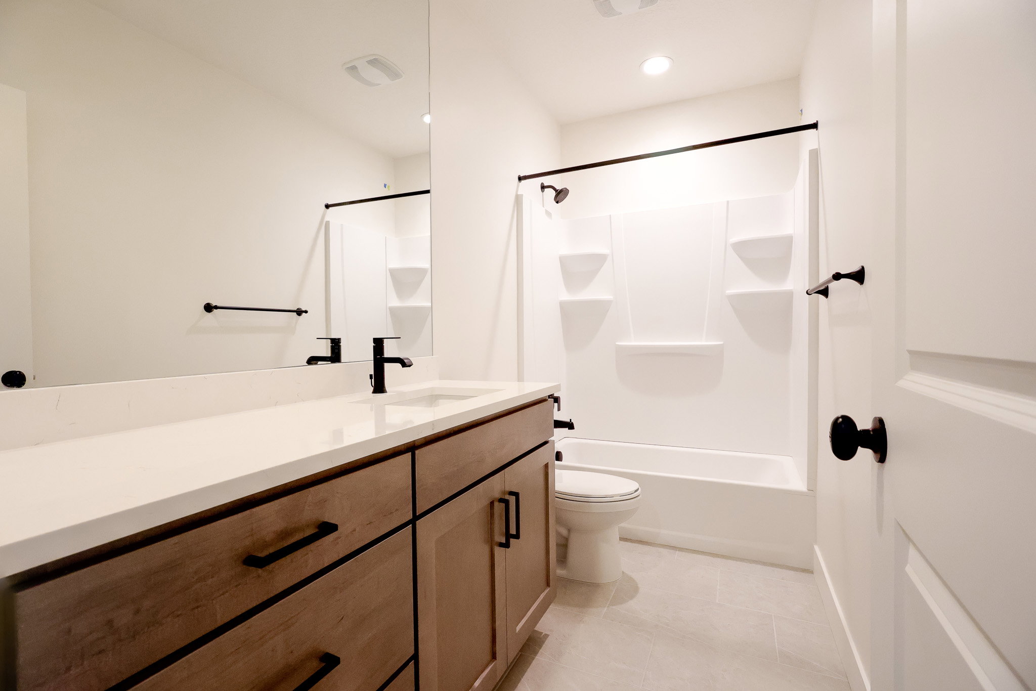 Basement Bathroom featuring vanity, shower / bath combination with curtain, light tile patterned flooring, and recessed lighting