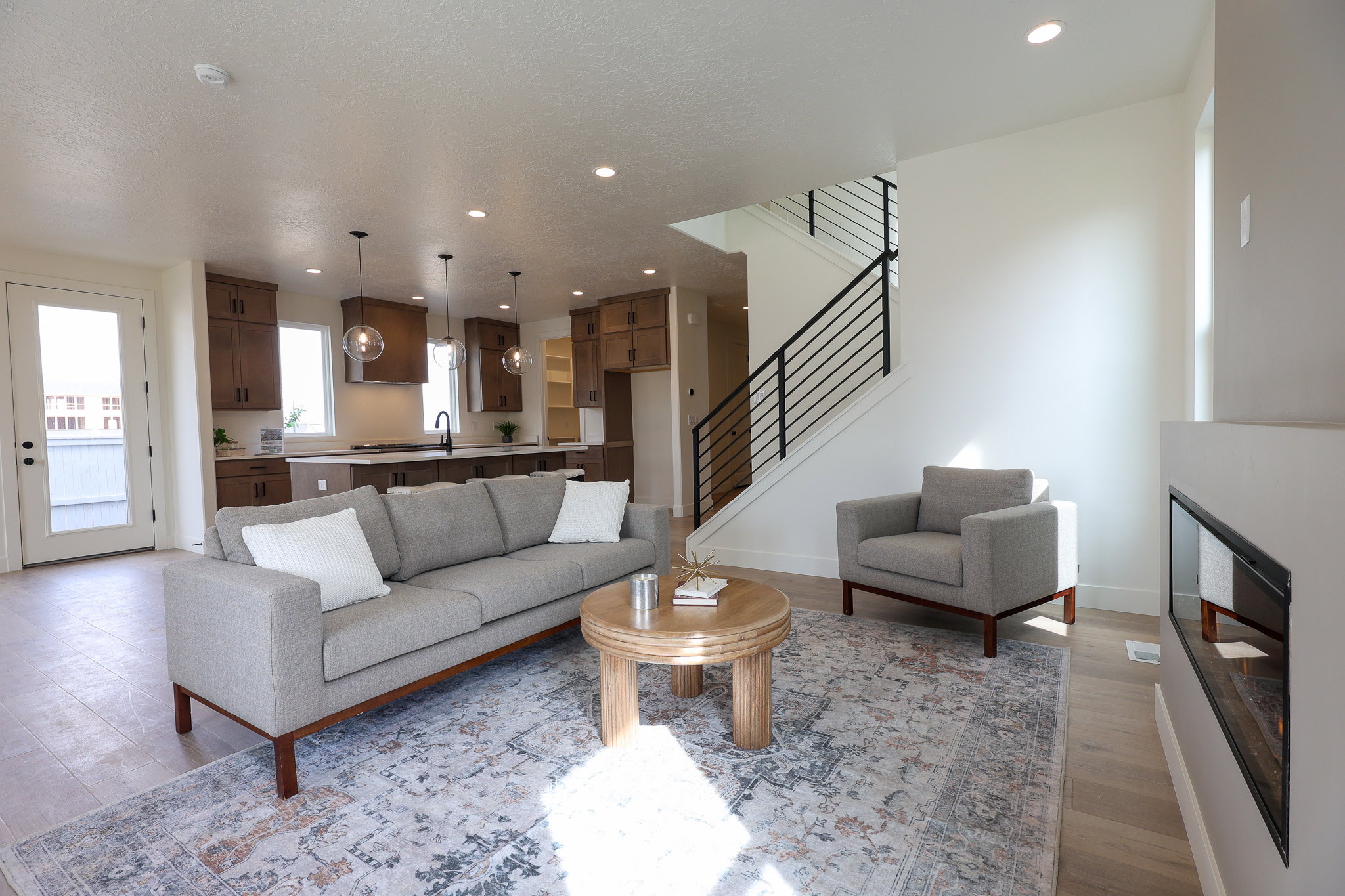 Living room with recessed lighting, light wood-style flooring, and a glass covered fireplace