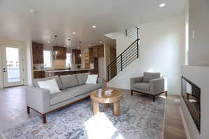 Living room with recessed lighting, light wood-style flooring, and a glass covered fireplace